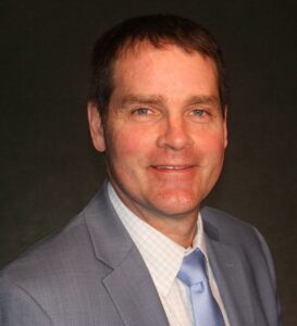 man in a light gray suit and blue tie