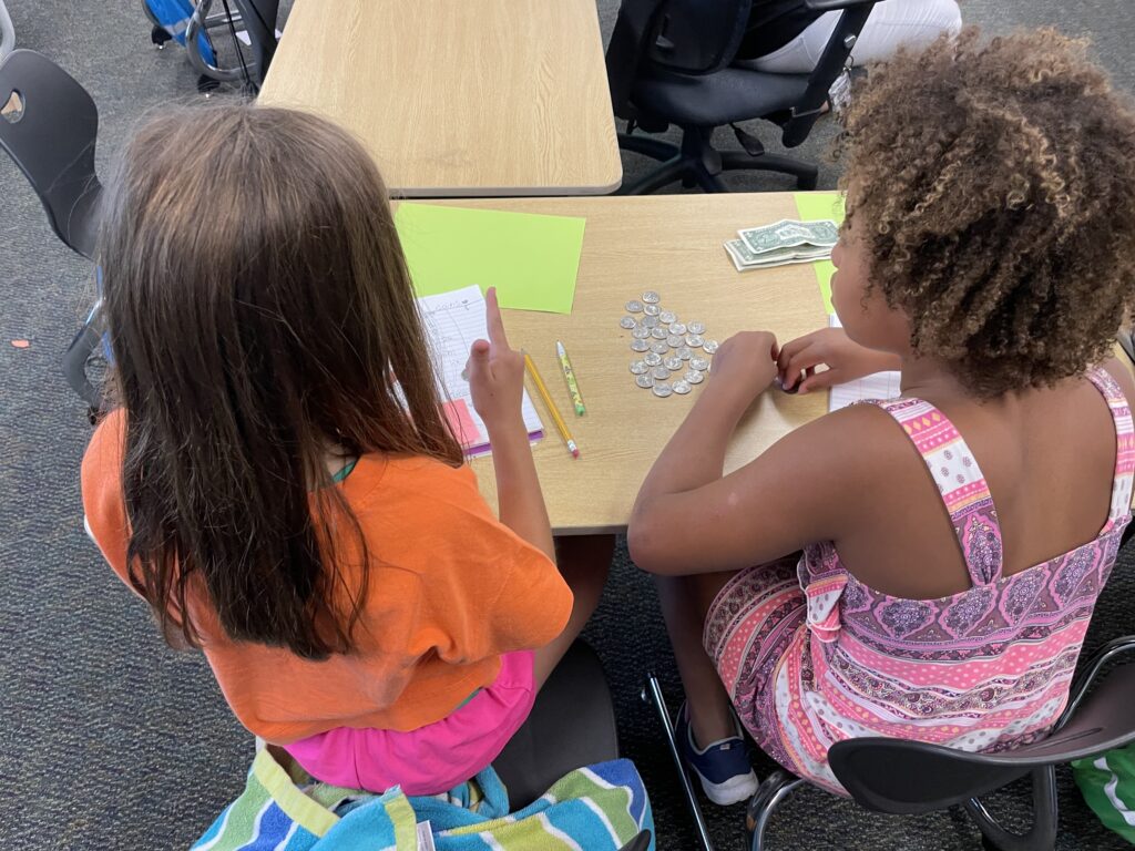 two students counting currency together