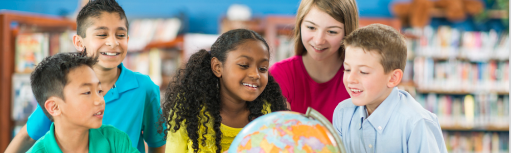 a group of diverse students in a media center looking at a globe